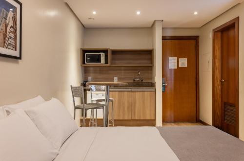 um quarto de hotel com uma cama e uma cozinha em Blue Tree Towers Millenium Porto Alegre em Porto Alegre