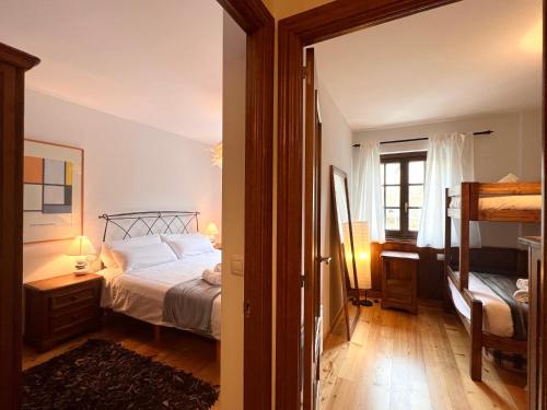 1 dormitorio con cama, ventana y espejo en Apartament de La Coma, en Llavorsí
