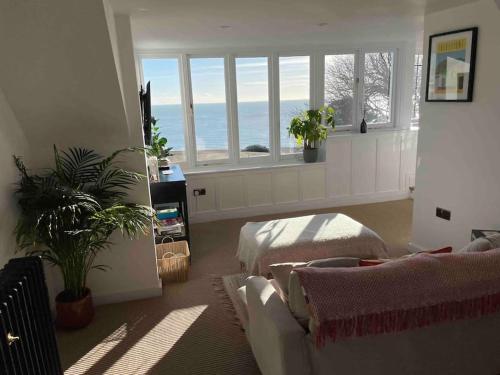 ein Wohnzimmer mit einem Sofa und einigen Fenstern in der Unterkunft The Turret- the best view in Folkestone in Folkestone