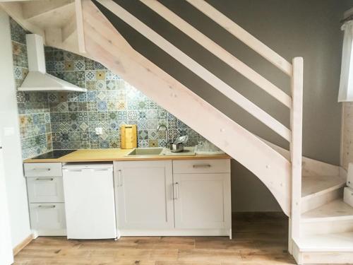 a kitchen with white cabinets and a staircase with a sink at WCZASOWISKO TOLKOWO in Jarosławiec