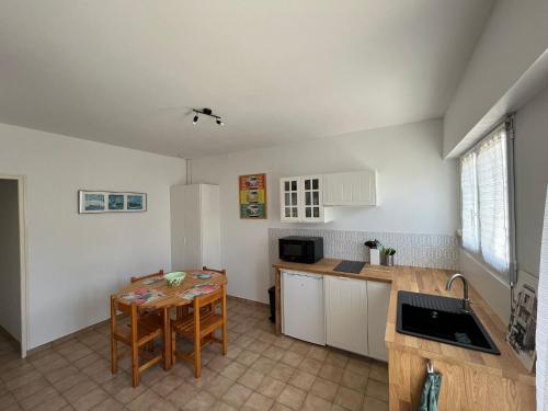 d'une cuisine avec une table et un évier, ainsi que d'un astérisque dans l'établissement La Tranche Cozy Stay!, à La Tranche-sur-Mer