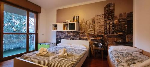 2 camas en una habitación con un mural de la ciudad en la pared en Spacious bright apartment near city center and Como lake with air conditioning, en Lecco