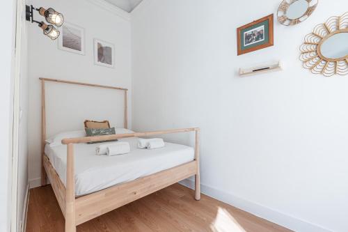 une chambre avec un lit avec des draps blancs et un miroir dans l'établissement Lively district - Duplex Old Town, à Nice