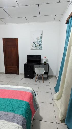 - un salon avec un lit et un bureau dans l'établissement La casa de don Matilde, à San Pedro Sula