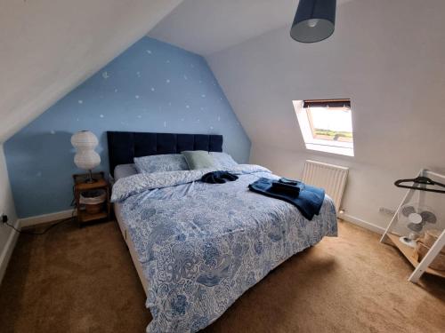 a bedroom with a bed and a blue wall at Fun family beach house! in Lessingham