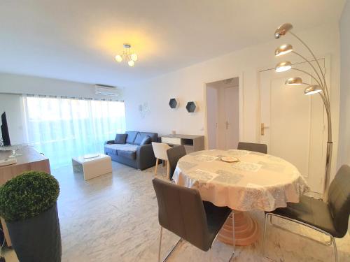 un salon avec une table et un canapé dans l'établissement Parc Imperial by Welcome to Cannes, à Cannes