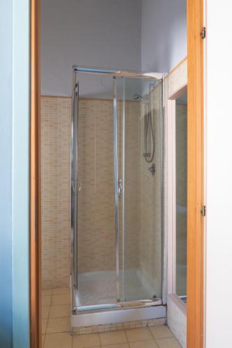 a shower with a glass door in a bathroom at Ostello degli Elefanti in Catania