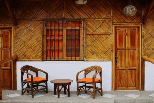 two chairs and a table in front of a building at HANGA ROA HOTEL in Montañita