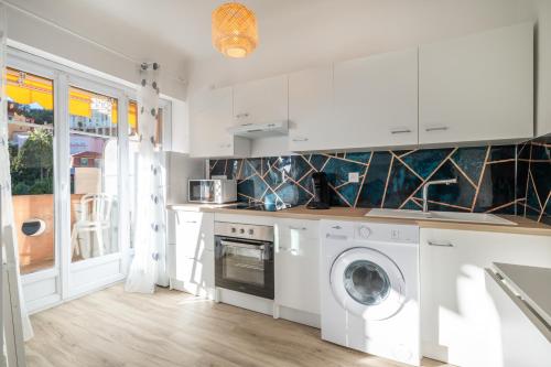 une cuisine blanche avec une machine à laver à l'intérieur dans l'établissement CASTEL 2 Studio au centre ville de Menton Gare SNCF, à Menton