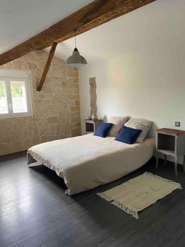 une chambre avec un grand lit avec des oreillers bleus dans l'établissement Maison 12-14 pers. avec piscine au cœur de la nature, à Vouneuil-sur-Vienne