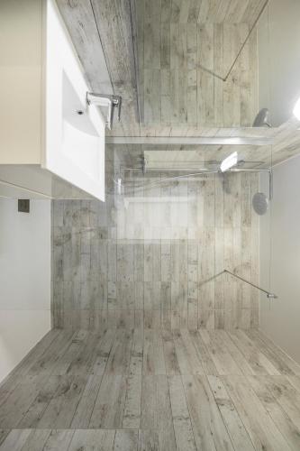 a bathroom with a shower with a wooden floor at CASTEL 2 Studio au centre ville de Menton Gare SNCF in Menton