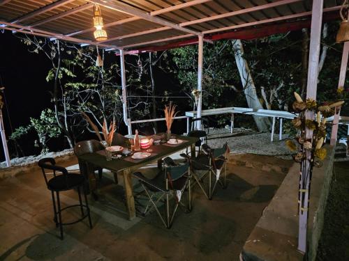 - une table et des chaises sur la terrasse la nuit dans l'établissement The Sweven NeerVan, à Rishikesh