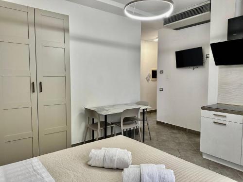 里米尼的住宿－Residence Rimini Relax，一间带一张床的房间和一间带桌子的厨房