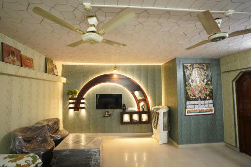 a living room with a ceiling fan and a tv at Kashi dham Homestay ( close to Kashi Vishwanath temple and Ghats) in Varanasi