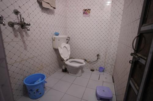 a small bathroom with a toilet in a stall at Kashi dham Homestay ( close to Kashi Vishwanath temple and Ghats) in Varanasi