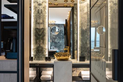 Art Suites Luxury Hotel في كراكوف: غرفة خلع الملابس مع مرآة ومغسلة