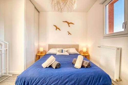 - une chambre dotée d'un lit bleu avec des oiseaux sur le mur dans l'établissement Le Nid Familial de Merville Maison neuve proche Plage 6 pers, à Merville-Franceville-Plage