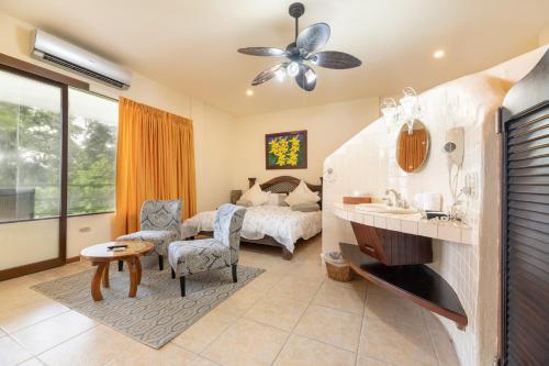 1 dormitorio con 1 cama y sala de estar en Issimo Suites (Adults Only), en Manuel Antonio