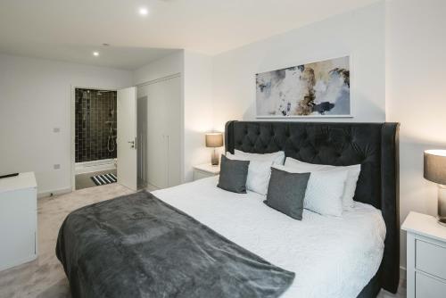1 dormitorio con 1 cama grande y cabecero negro en Stunning 3-Bed Apartment in London, en Londres
