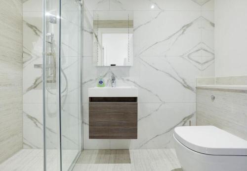 biała łazienka z prysznicem i toaletą w obiekcie Rye Exclusive new apartment w mieście Rye