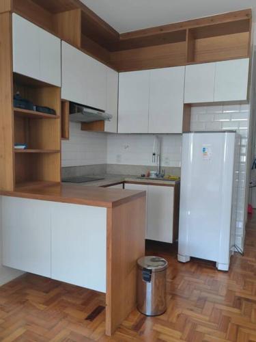 una cucina con mobili bianchi e un frigorifero bianco di Apê na Rua das Palmeiras Imperiais a Rio de Janeiro