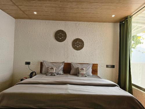 a bedroom with a large bed with two pillows at The Sweven NeerVan in Rishīkesh