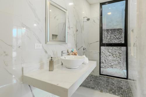 a white bathroom with a sink and a shower at Meriblau Hotel Boutique in Mérida