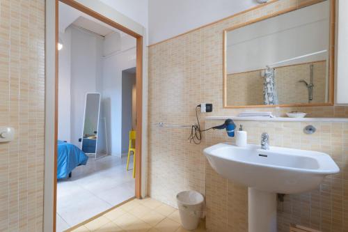 a bathroom with a sink and a shower with a mirror at Ostello degli Elefanti in Catania