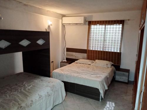 a bedroom with two beds and a window at Apartamento playero en Lecheria in El Morro de Barcelona