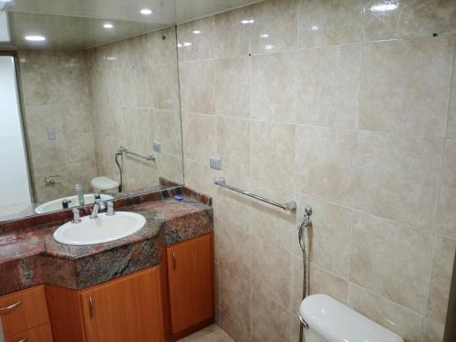 y baño con lavabo, aseo y espejo. en Apartamento playero en Lecheria en El Morro de Barcelona