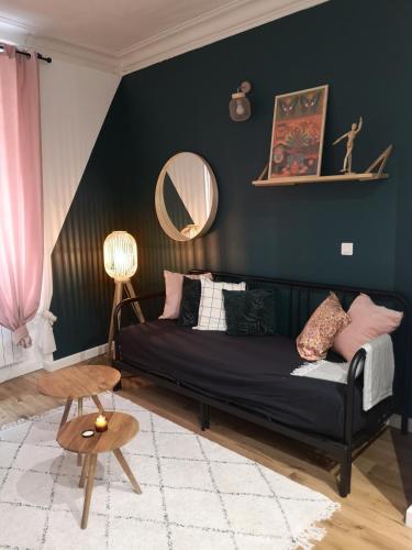 - un salon avec un canapé noir et un miroir dans l'établissement Charme et confort en plein centre historique, à Nantes