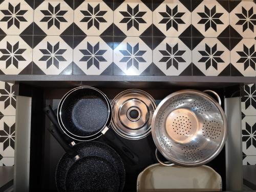 un tas de casseroles et de poêles sur une étagère dans une cuisine dans l'établissement Charme et confort en plein centre historique, à Nantes