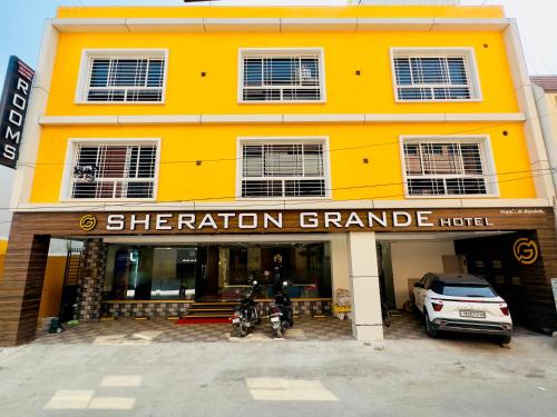 a yellow building with a car parked in front of it at Sheraton Grande at Puratchi Thalaivar Dr MGR Central Railway Station in Chennai