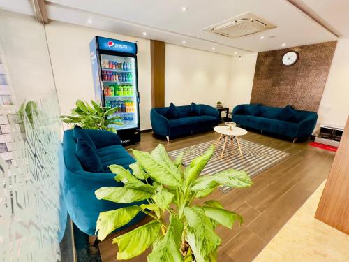 a lobby with a soda machine and blue couches at Sheraton Grande at Puratchi Thalaivar Dr MGR Central Railway Station in Chennai