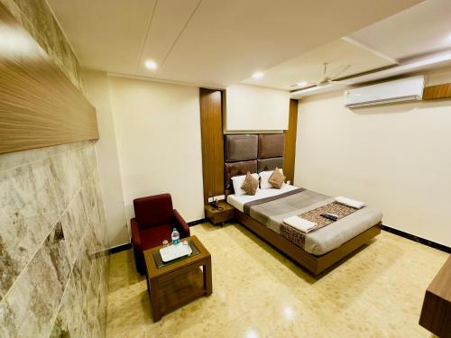 a bedroom with a bed and a red chair at Sheraton Grande at Puratchi Thalaivar Dr MGR Central Railway Station in Chennai