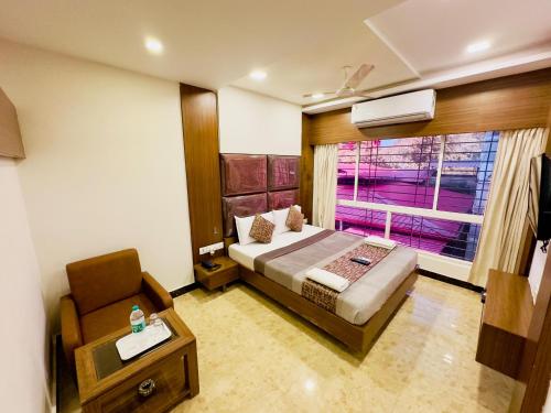 a bedroom with a bed and a chair and a window at Sheraton Grande at Puratchi Thalaivar Dr MGR Central Railway Station in Chennai