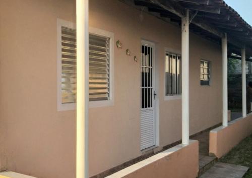 una casa con dos ventanas y un poste al lado en Casa de praia Barra do Ribeira Juréia Iguape SP, en Iguape