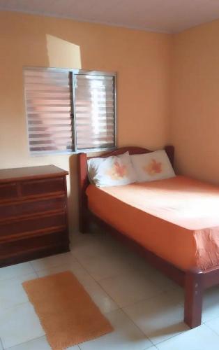 1 dormitorio con 1 cama con tocador y ventana en Casa de praia Barra do Ribeira Juréia Iguape SP, en Iguape