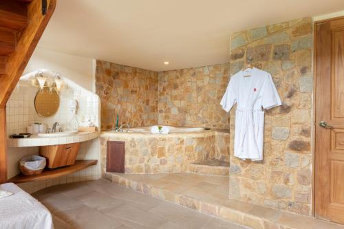 a bathroom with a tub and a robe on a wall at Issimo Suites (Adults Only) in Manuel Antonio