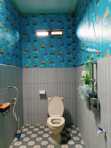 uma casa de banho com WC numa casa de banho com paredes azuis em homestay mentari em Curup