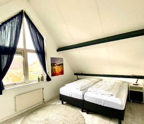 a bedroom with two beds and a large window at Kustverhuur, Park Scheldeveste Zwin 010 in Breskens