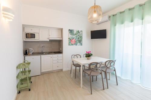 uma cozinha e sala de jantar com mesa e cadeiras em Faro Guest Apartments em Faro