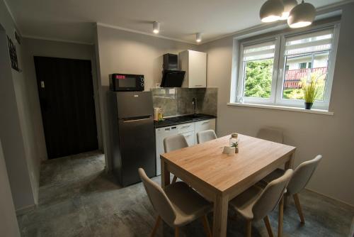 een keuken met een houten tafel en een tafel met stoelen bij FMA ski & bike in Szklarska Poręba