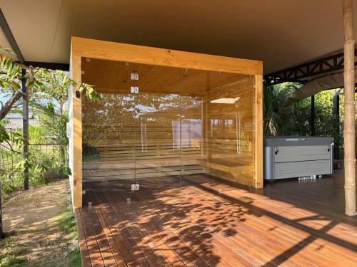 a wooden house with a wooden deck with a bathroom at HBG Glamping community Yoga & Wellness space in Santa Teresa Beach