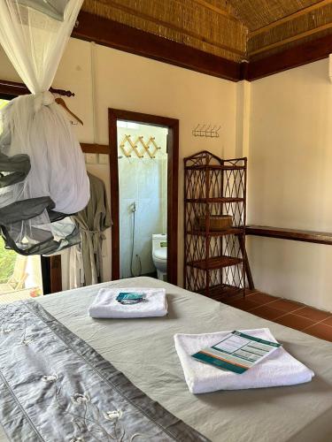 a bedroom with a bed with two towels on it at Beach House Cambodia in Koh Rong Sanloem