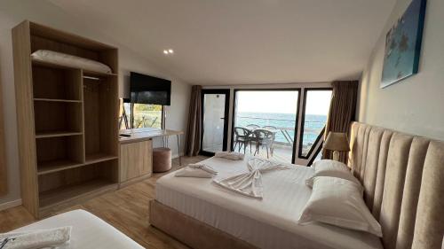 a bedroom with a bed and a view of the ocean at Hotel Tramonto Vlore in Vlorë