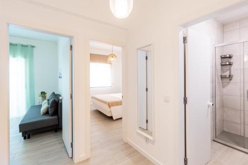 een badkamer met een douche en een bed in een kamer bij Faro Guest Apartments in Faro