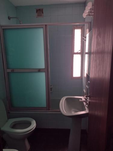 baño con lavabo y aseo y ventana en Edificio Bianini en Rosario