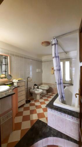 a bathroom with a tub and a toilet and a sink at Appartamento La Vista in Budoni