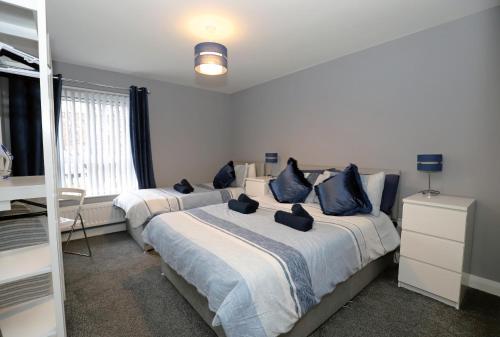 a bedroom with two beds with blue pillows at Harbour View City Centre Apartment in Belfast